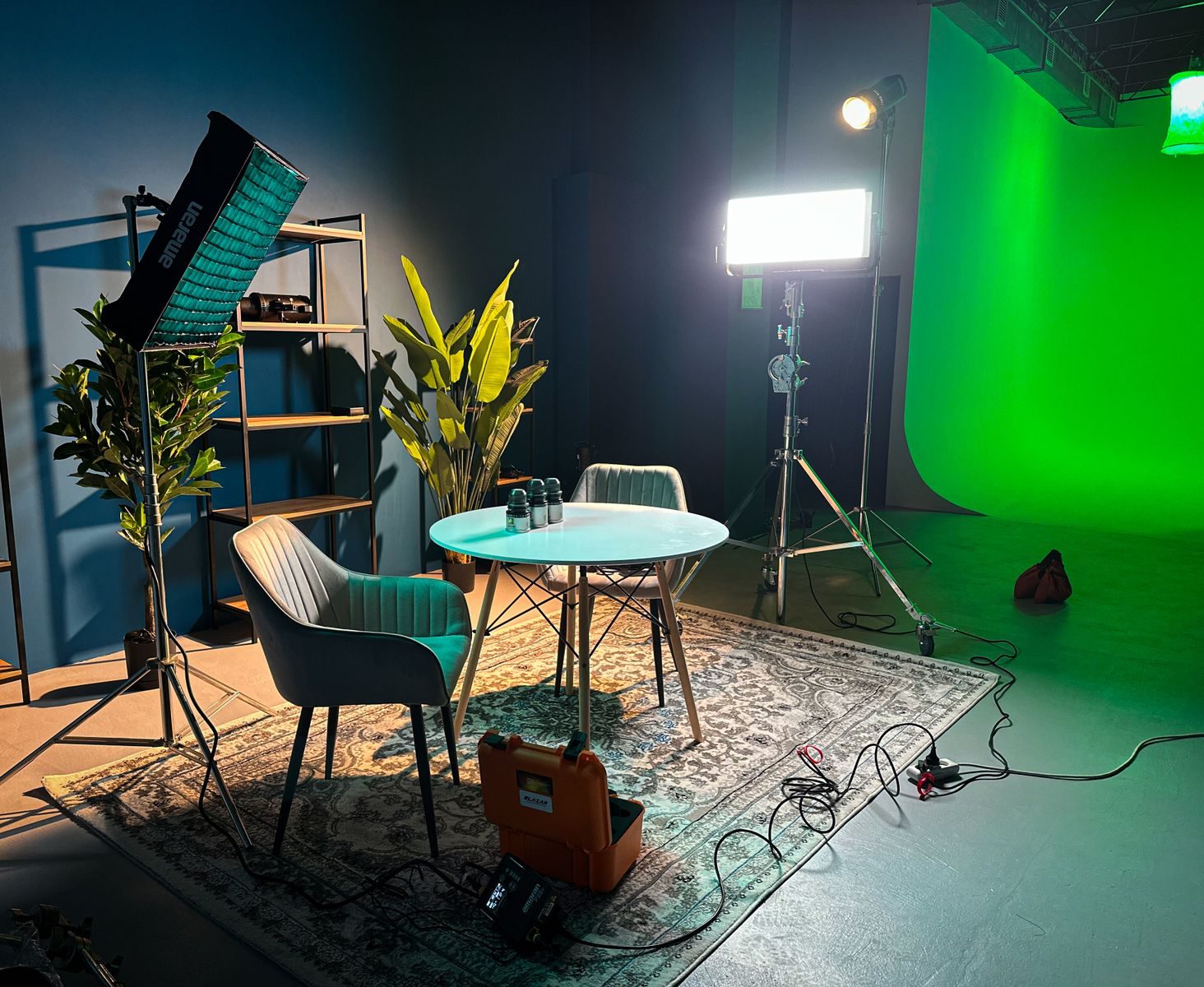 Estúdio interno moderno e bem iluminado para filmagem, com fundo verde e decoração elegante
